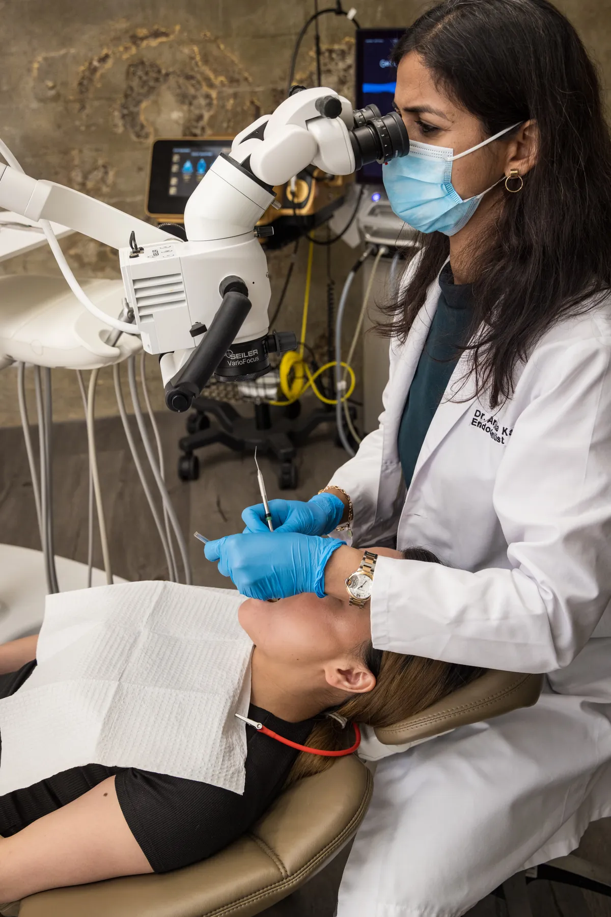 An Endospecialists endodontist treating a patient under a surgical operating microscope